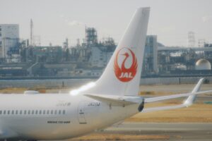 Japan airlines airplane tail with industrial background